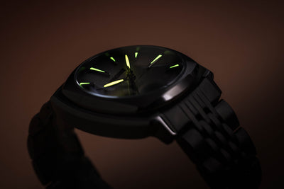 Wristwatch with moon phase, cool grey dial with luminous hands and markers.
